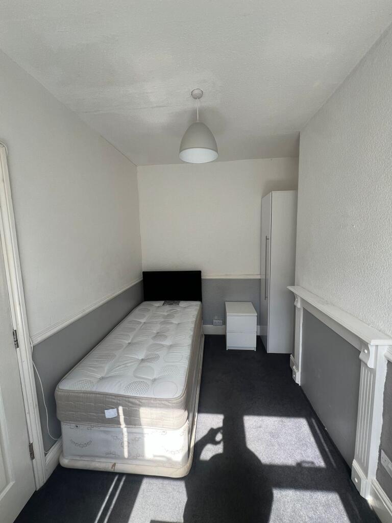 A bright and tidy single bedroom featuring a co...