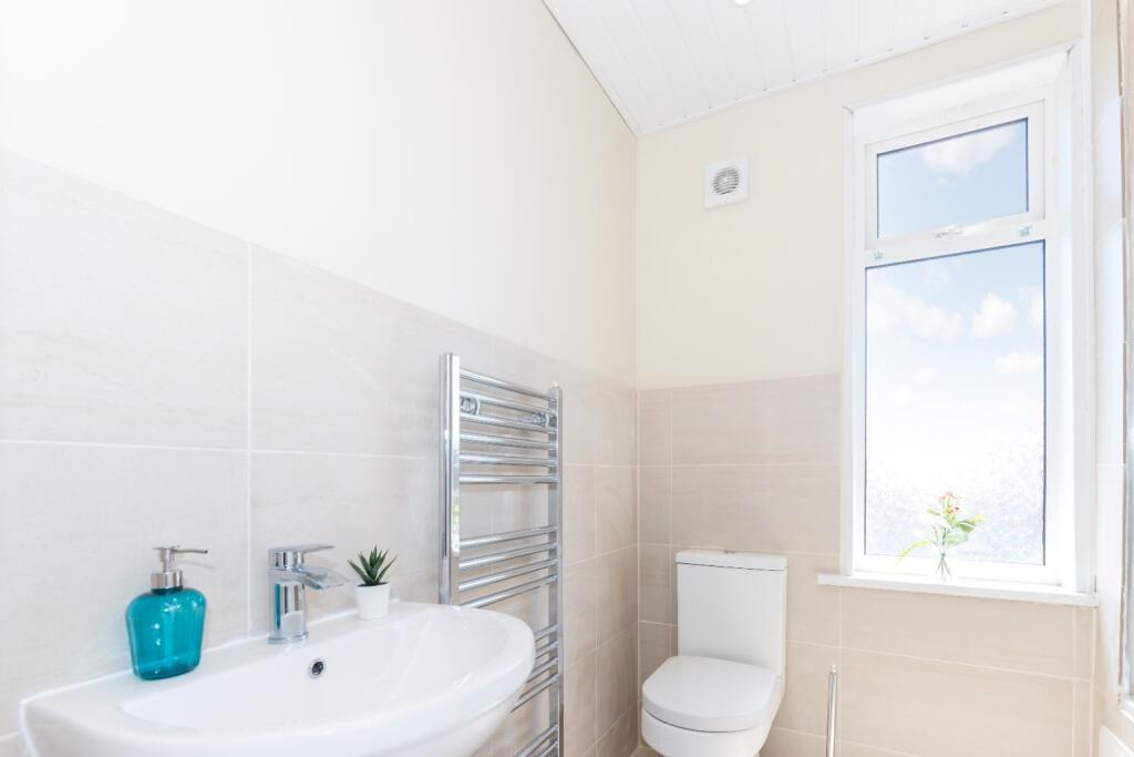 This bright and modern bathroom features a styl...