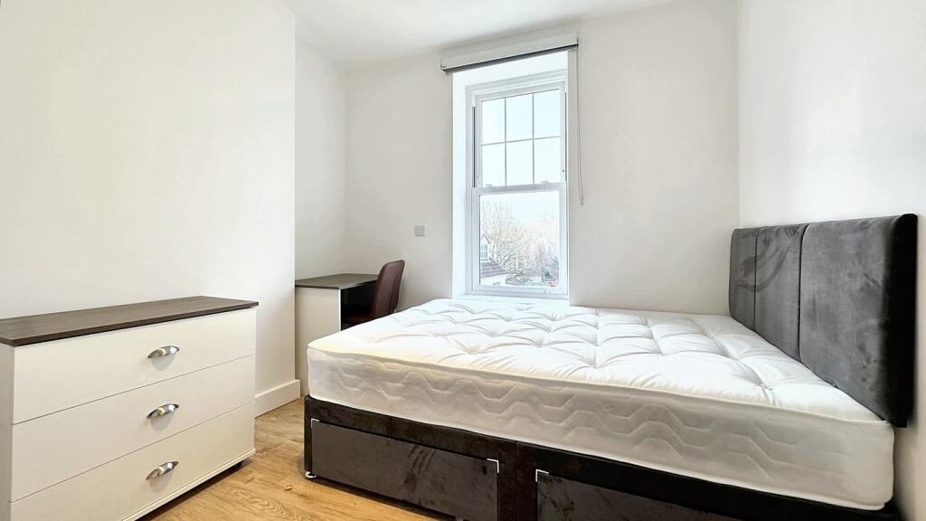 This inviting double bedroom features a comfort...