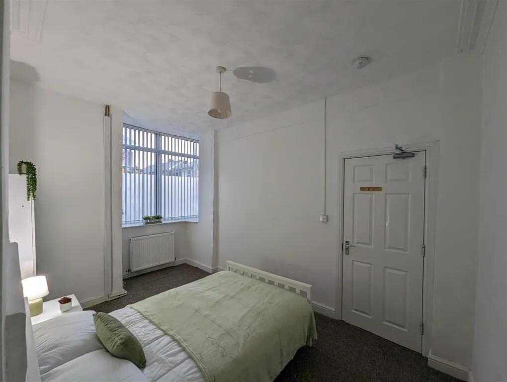 A bright, tidy bedroom featuring a single bed w...