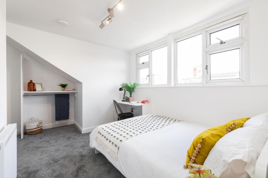 Bright and welcoming double bedroom featuring a...