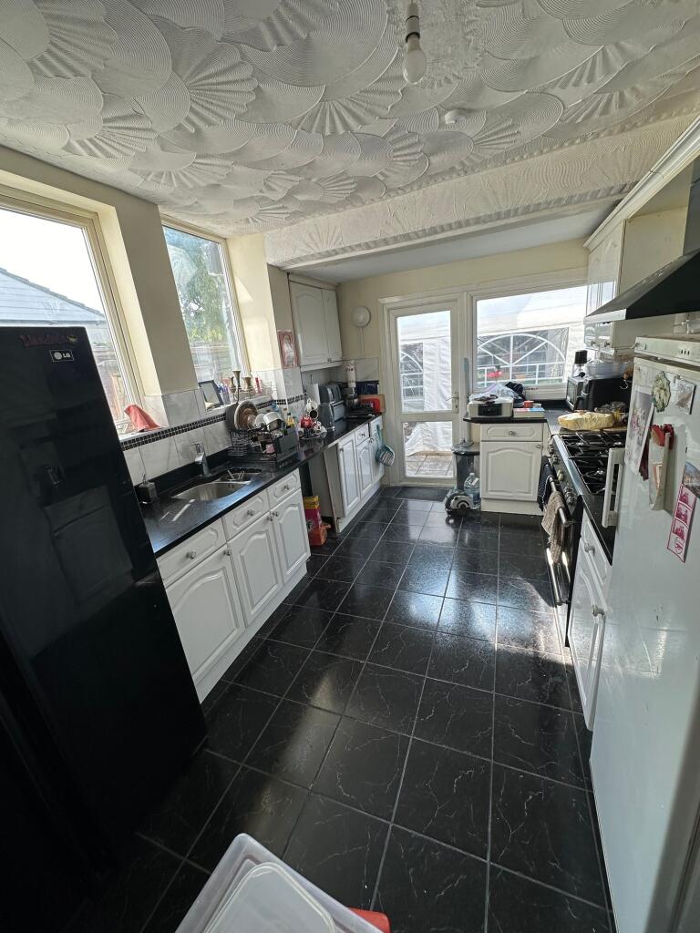 Bright kitchen featuring sleek black countertop...