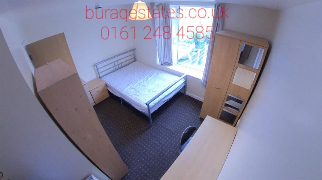 Bright single bedroom with a simple metal bed f...