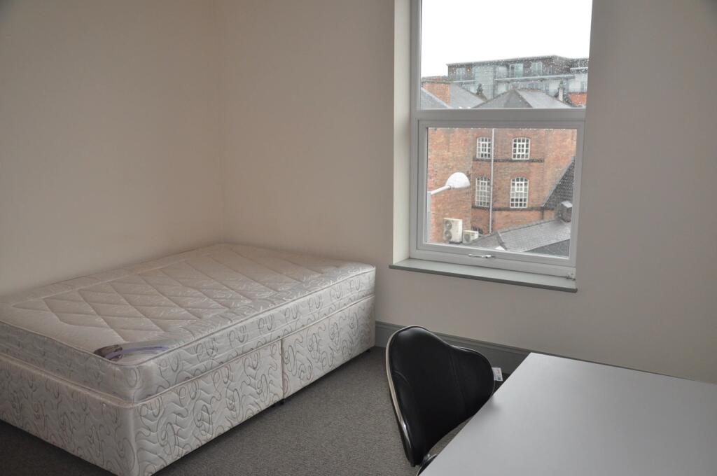 A spacious double bedroom with ample natural li...