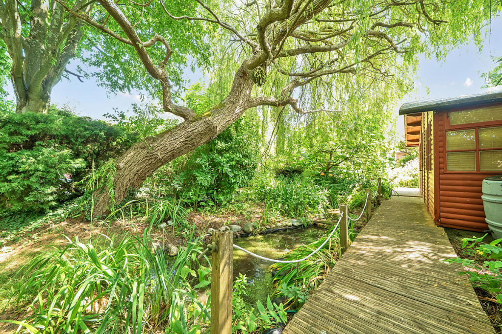 Mature trees and shrubs providing privacy and seclusion including an illuminated walkway to the detached home office