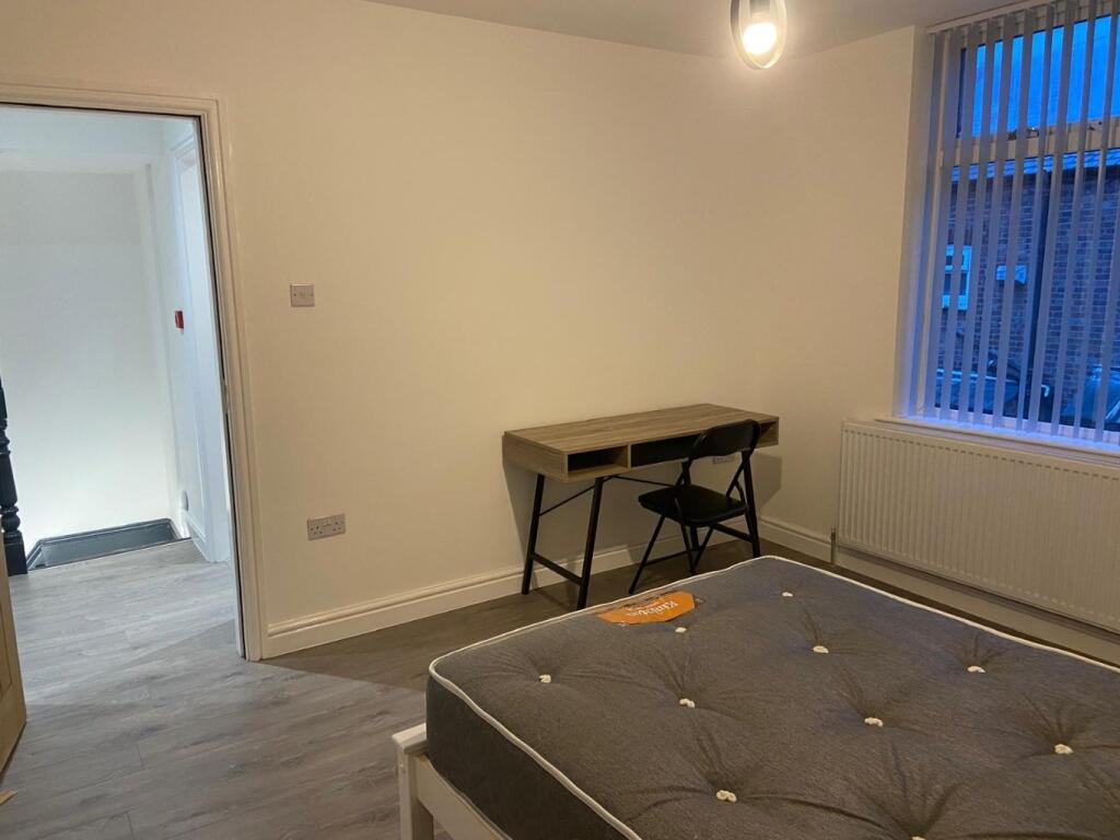 Bright, simply furnished bedroom with a comfort...