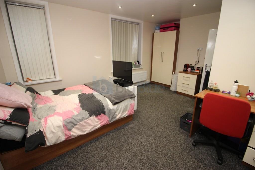 A neat and cozy single bedroom featuring a comf...
