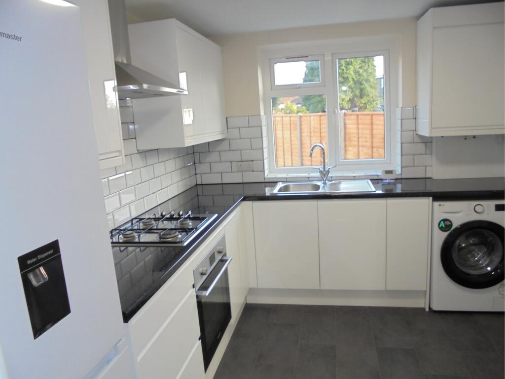 A modern and clean kitchenette with ample stora...