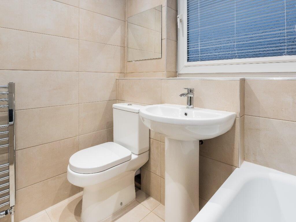 A bright and clean modern bathroom suite featur...