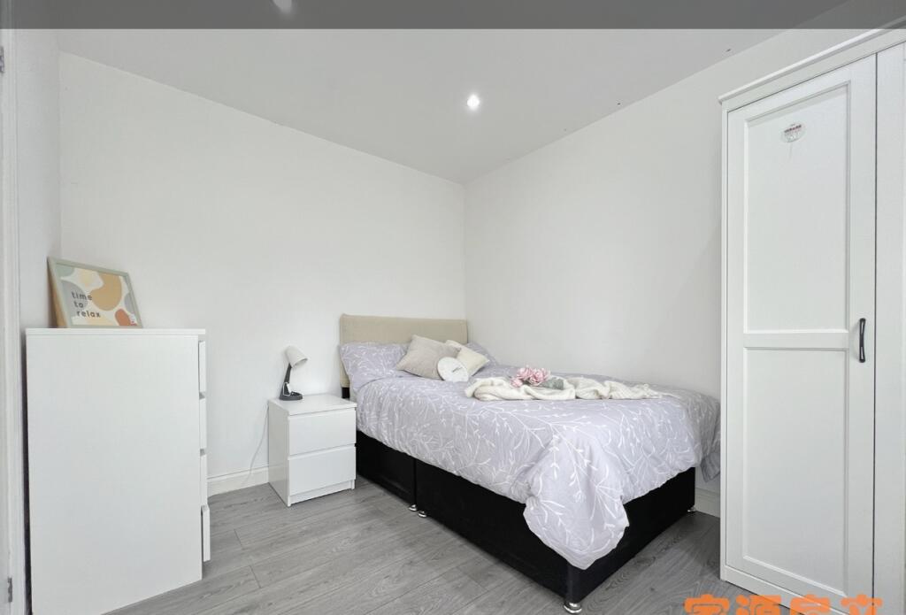 A neat and tidy single bedroom featuring a cozy...