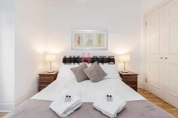 A welcoming double bedroom featuring a neatly m...