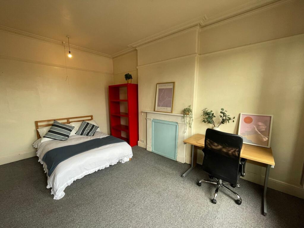Bright and cozy bedroom featuring a neatly made...