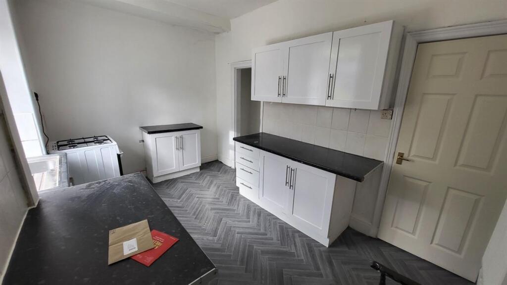 Bright fitted kitchen with white wall cabinets,...