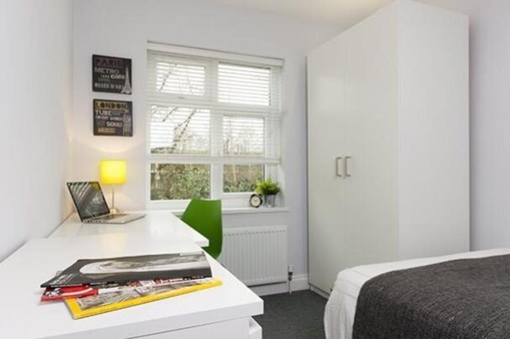 A bright and organized double bedroom with mode...