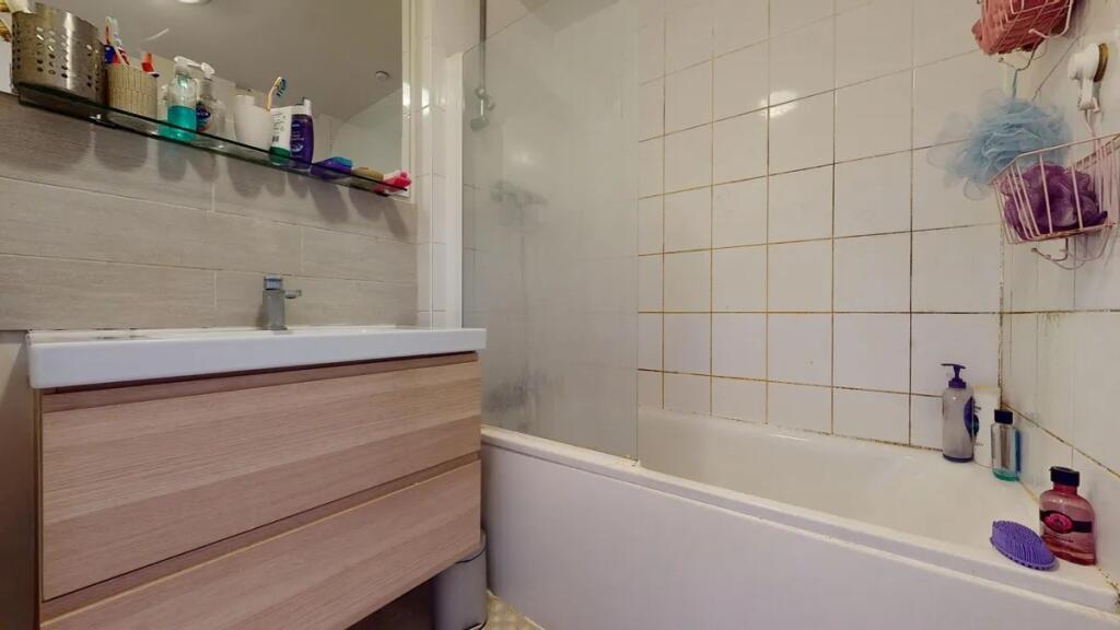 A functional bathroom suite featuring a bathtub...