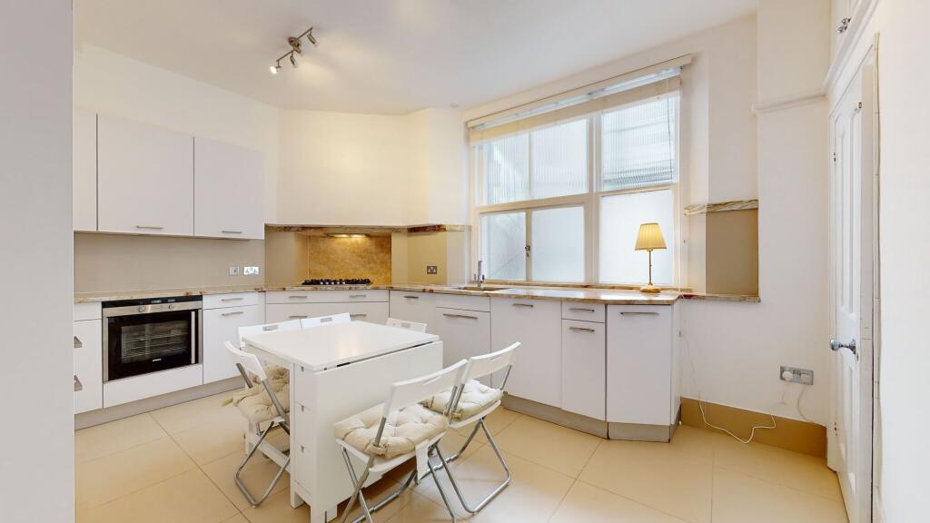 Bright and modern kitchen featuring sleek white...