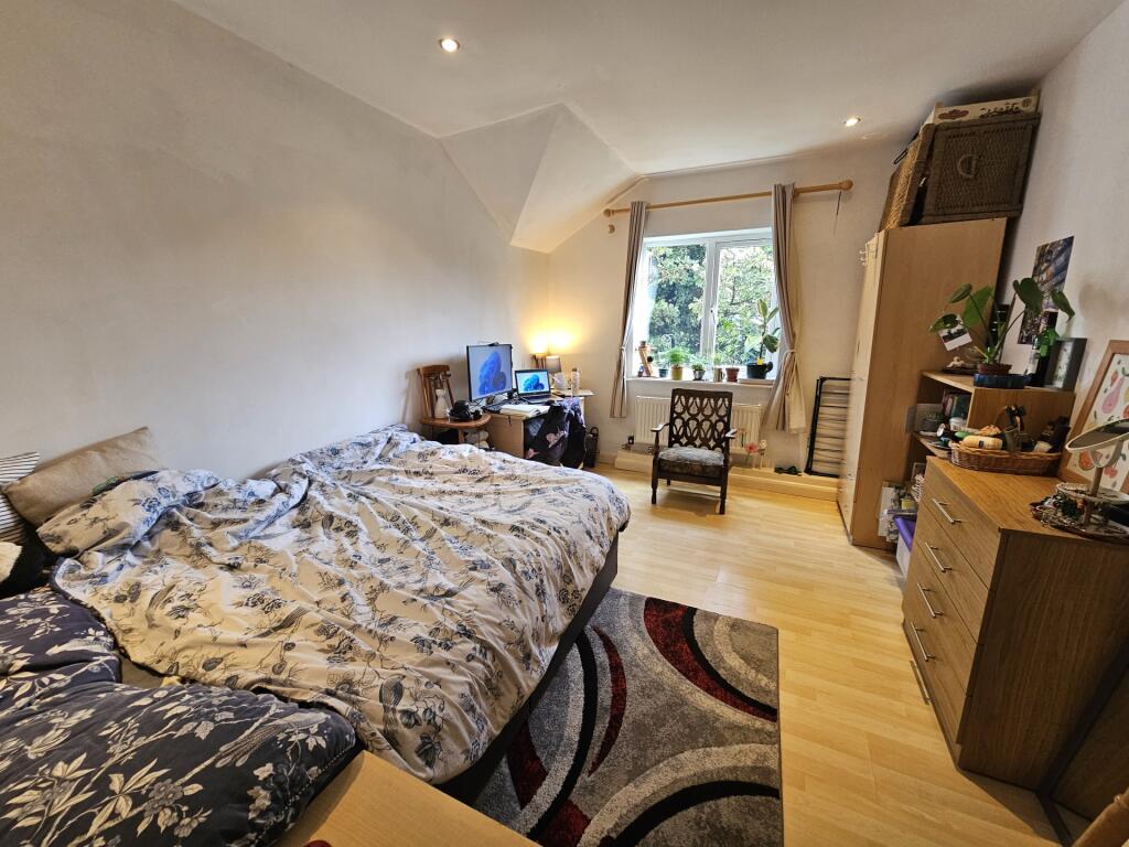 A cozy bedroom featuring a double bed with a pa...