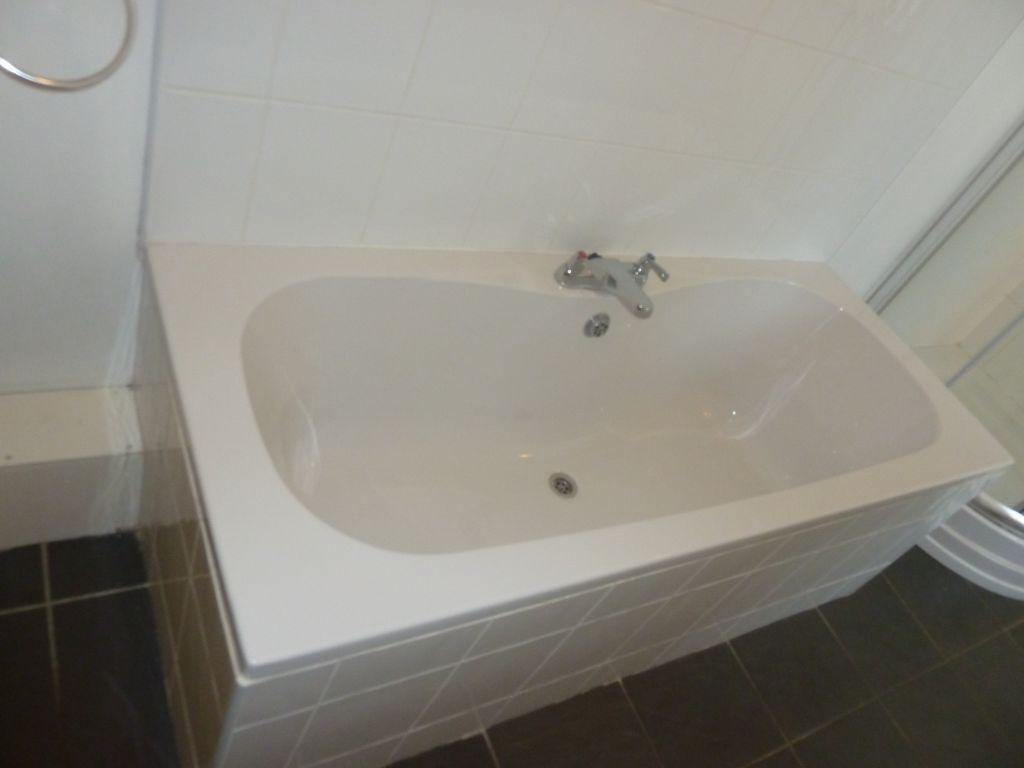 A clean and modern bathroom suite featuring a s...