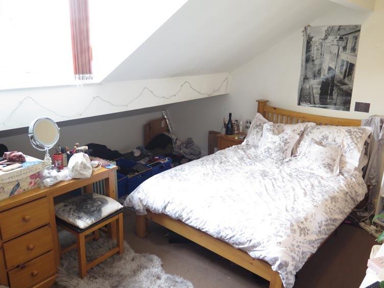 A cozy bedroom featuring a double bed with a li...