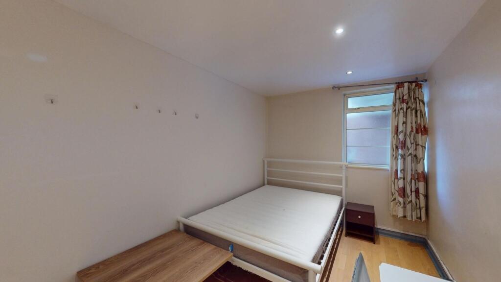 A bright and simple double bedroom featuring a ...