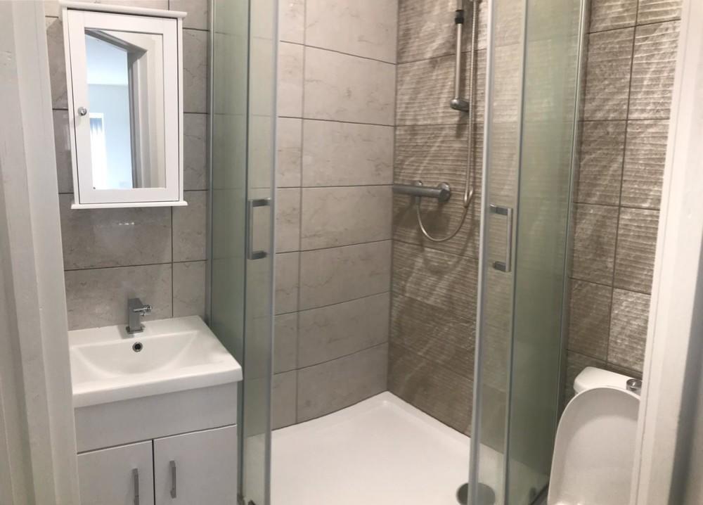 A modern bathroom featuring a spacious walk-in ...