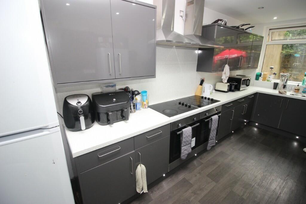 Modern kitchen with sleek grey cabinets, black ...