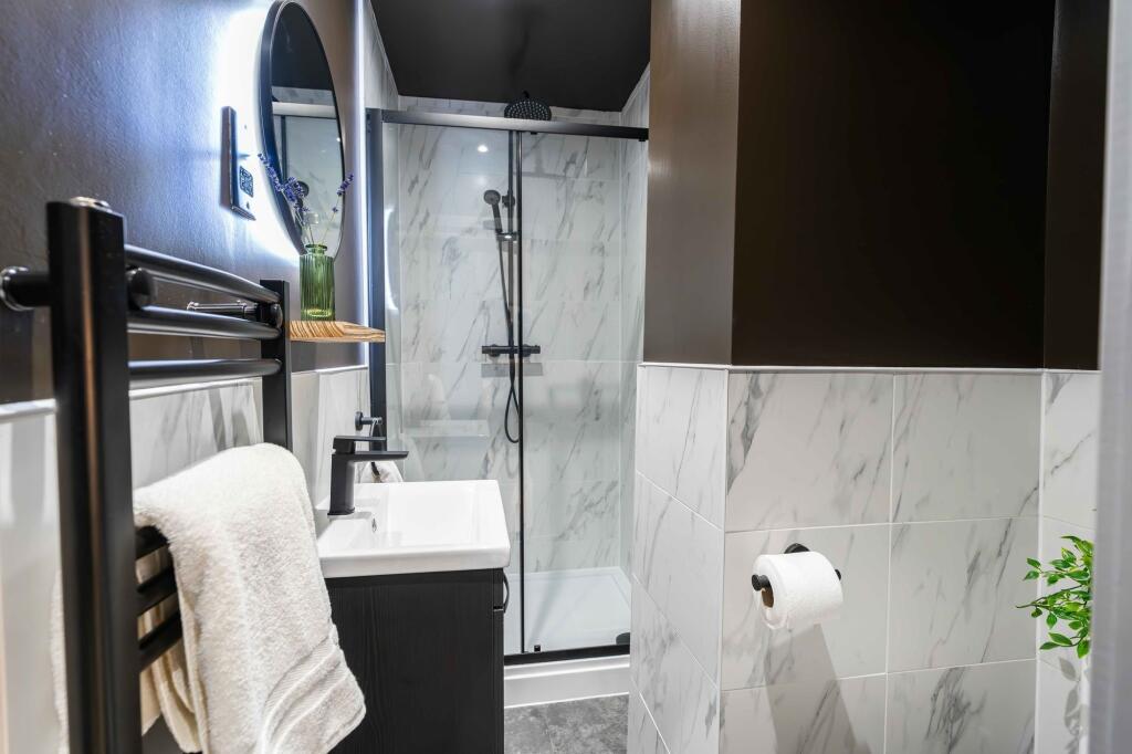 Modern and stylish bathroom featuring white mar...