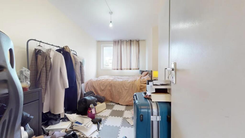 A compact double bedroom featuring a comfortabl...