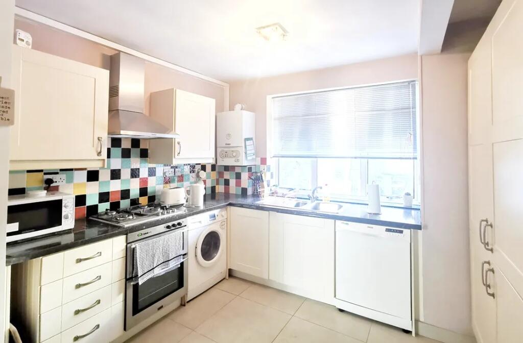 Bright and modern kitchen featuring colorful ti...