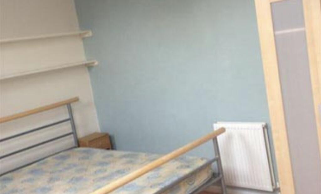 Simple furnished bedroom with a metal-framed be...