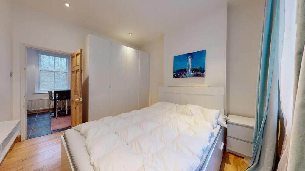 A bright double bedroom featuring a comfortable...