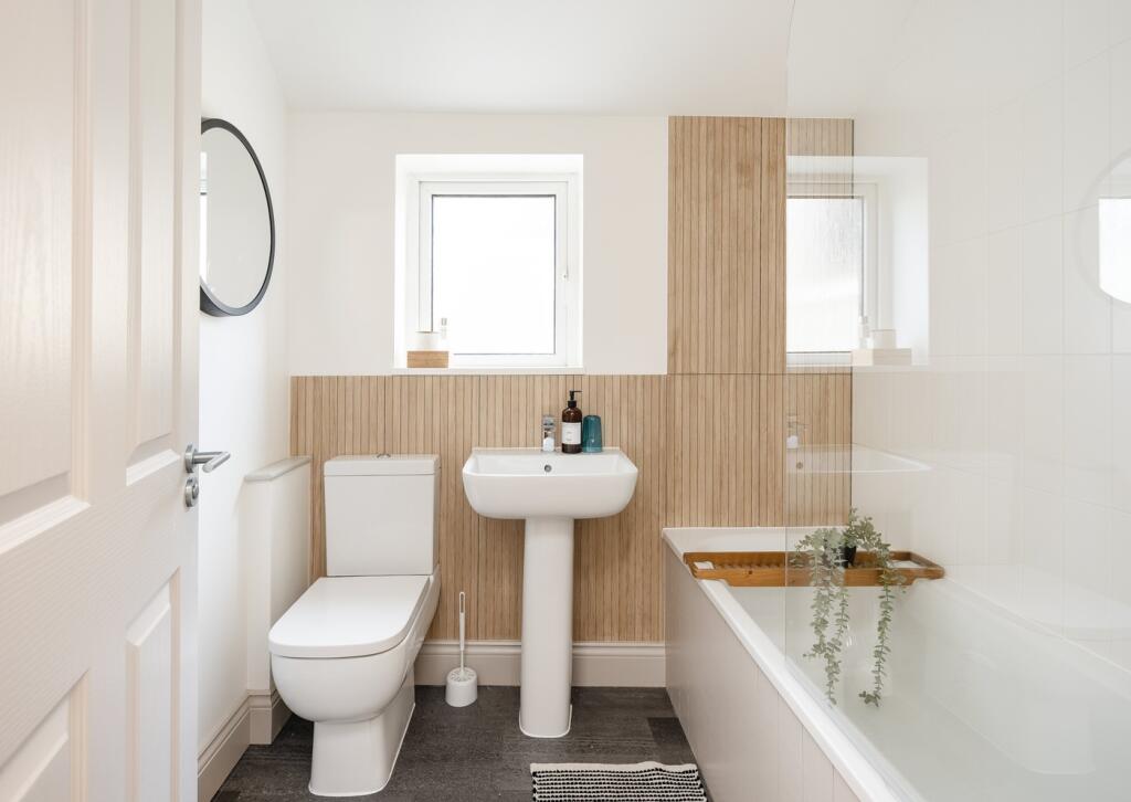 A modern and clean bathroom featuring a bath, s...