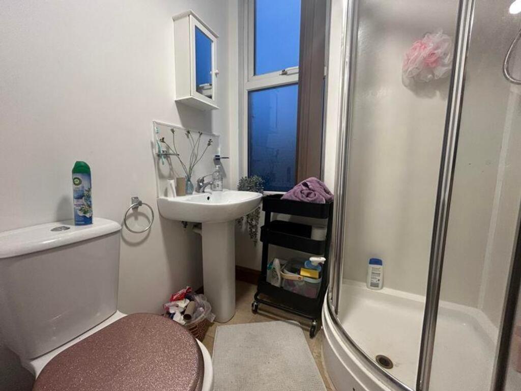 A tidy bathroom featuring a shower and essentia...