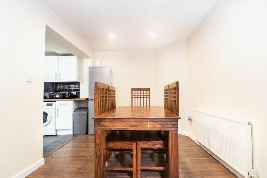 A spacious and well-lit kitchenette with a dini...