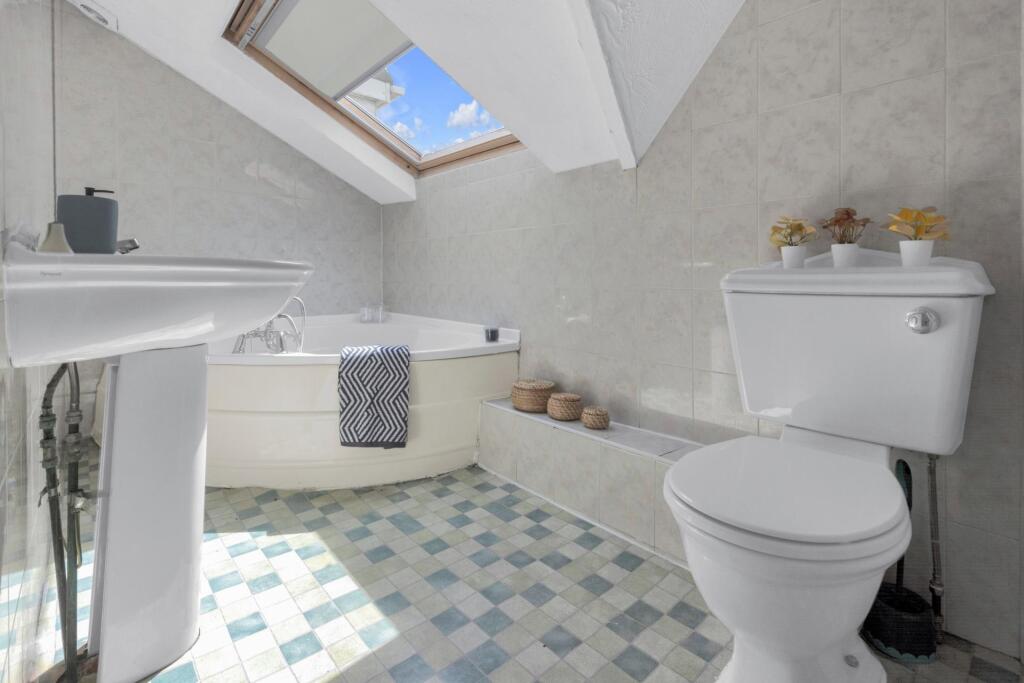 Bright and clean bathroom suite featuring a spa...