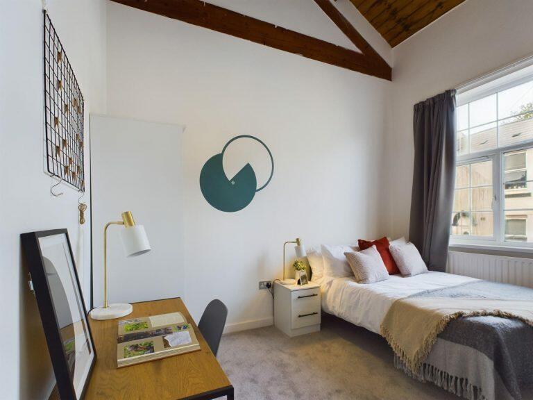 A cozy and neatly arranged single bedroom featu...