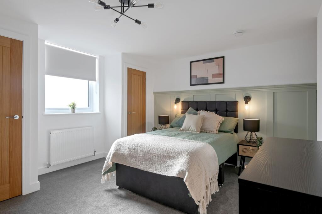 A modern and well-lit bedroom featuring a comfo...