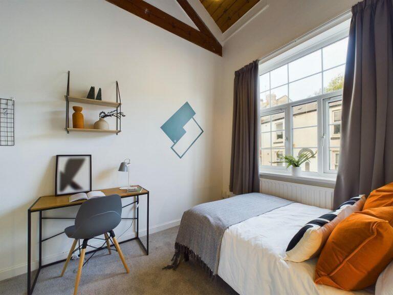 Bright and cozy bedroom featuring a comfortable...