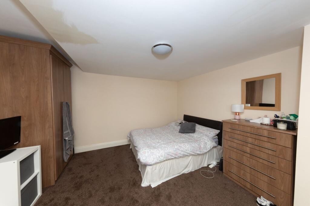 A cozy double bedroom featuring a large bed wit...