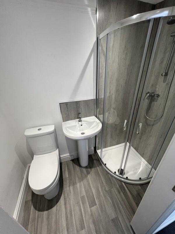 A modern bathroom featuring a sleek curved glas...