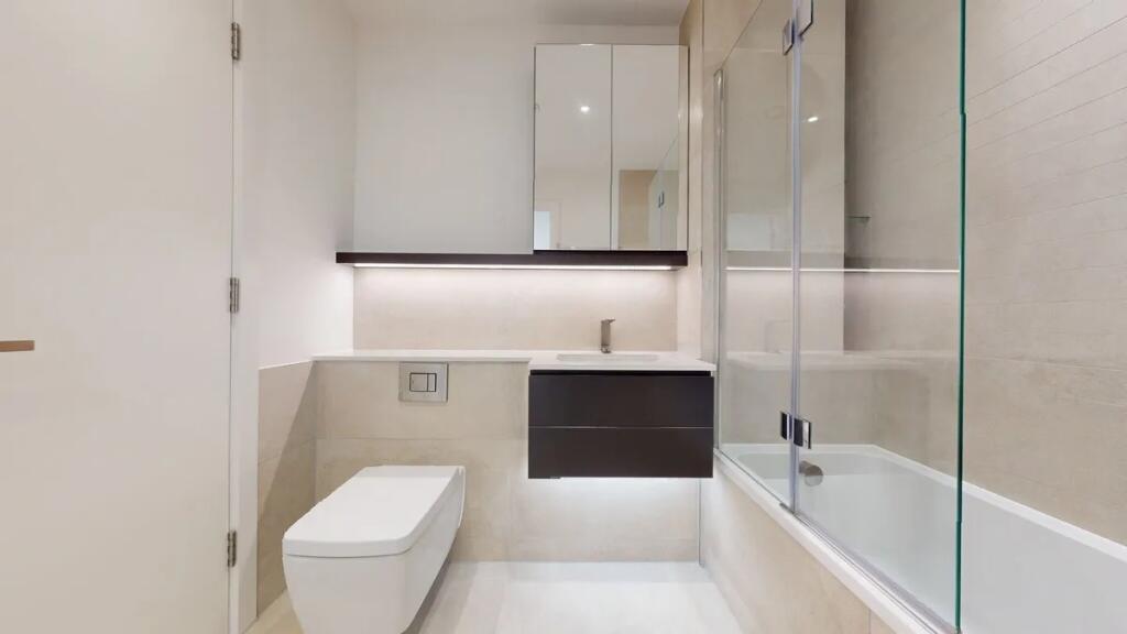 A modern and pristine bathroom suite featuring ...