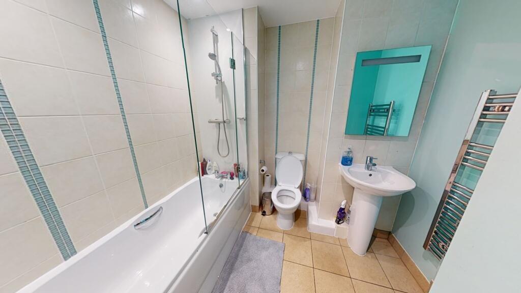 A bright, clean, and modern bathroom suite feat...