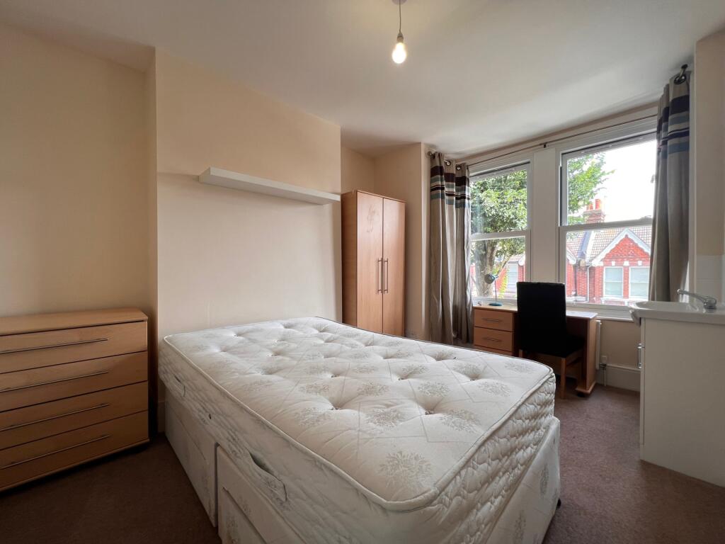A tidy single bedroom featuring a comfortable b...