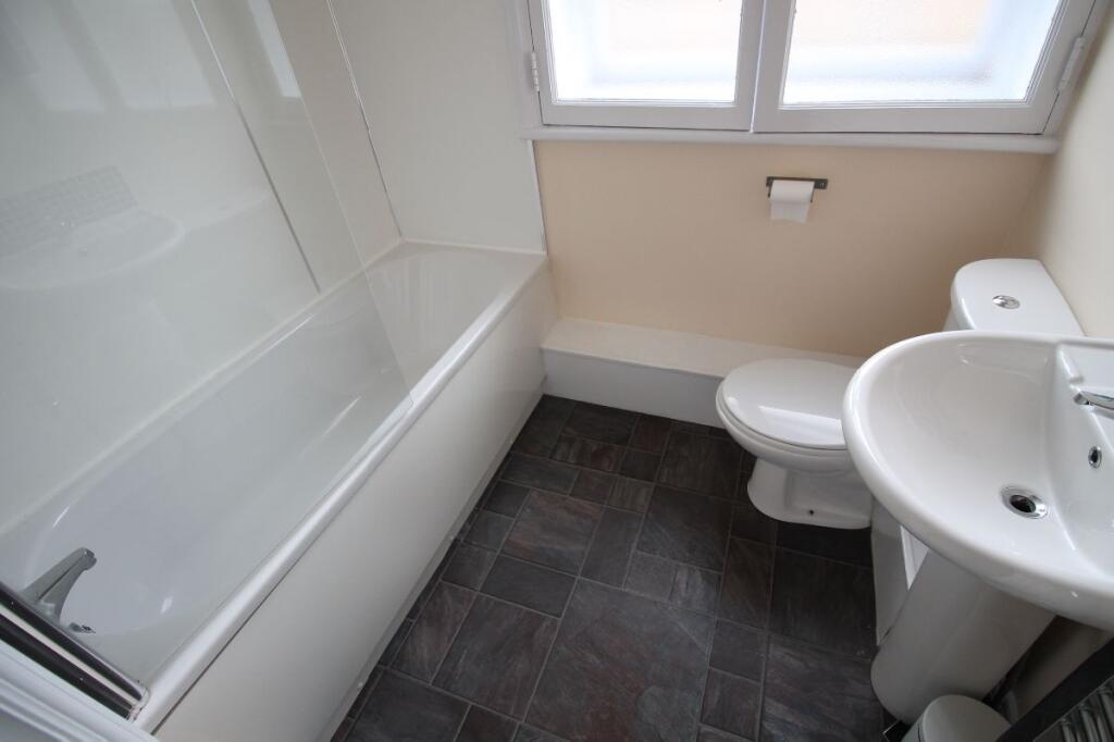 A clean and modern bathroom featuring a white b...