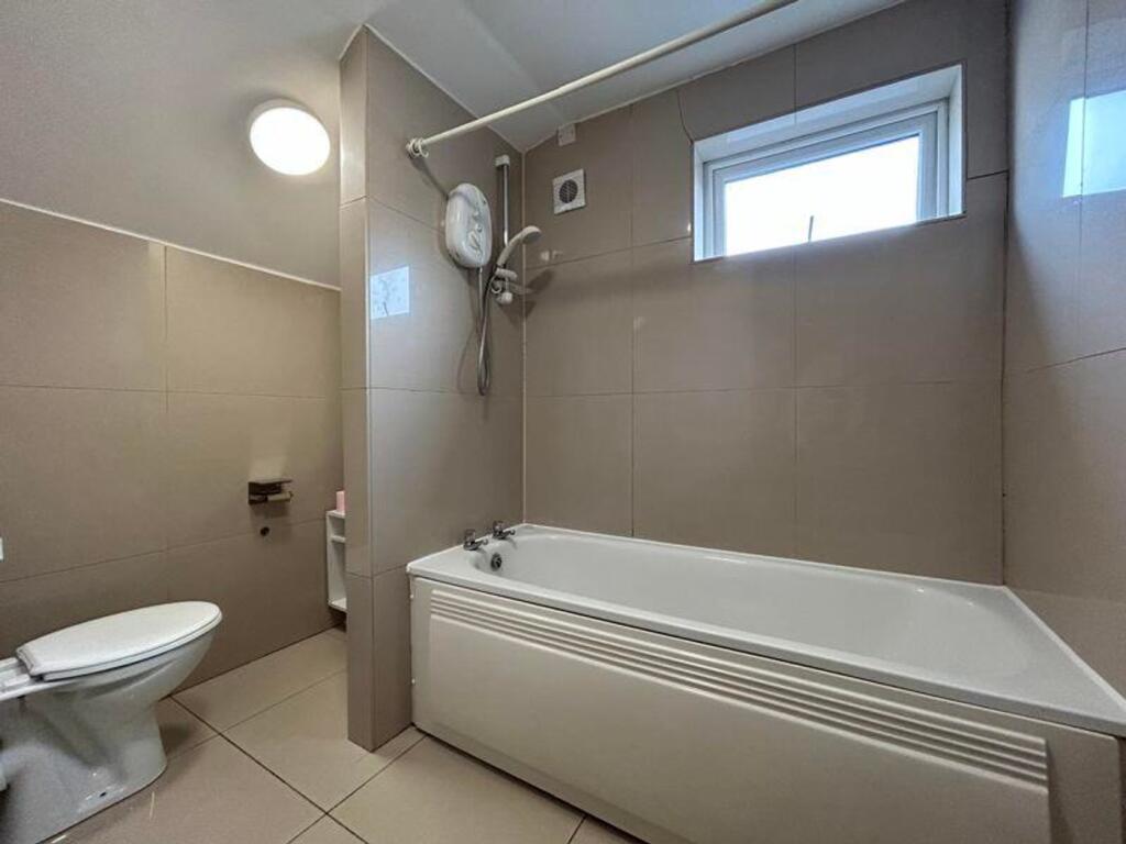 A spacious and modern bathroom featuring a bath...