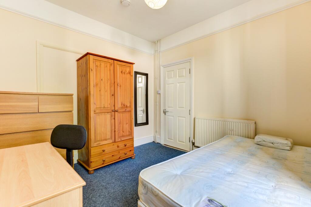 A tidy and inviting bedroom featuring a comfort...