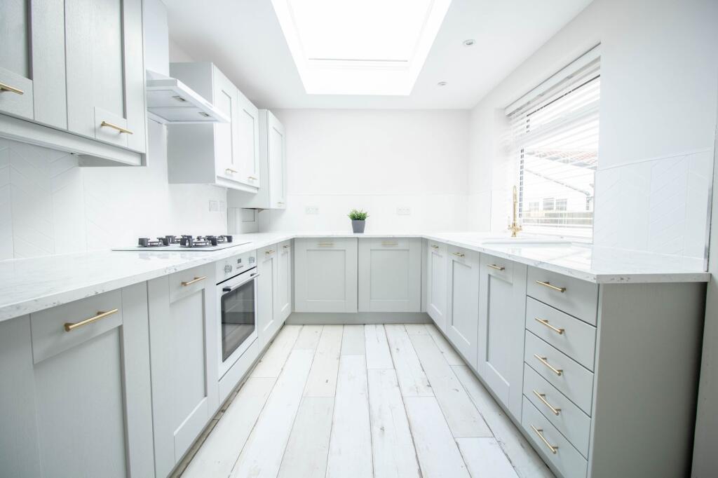 Bright, modern kitchen with ample white cabinet...