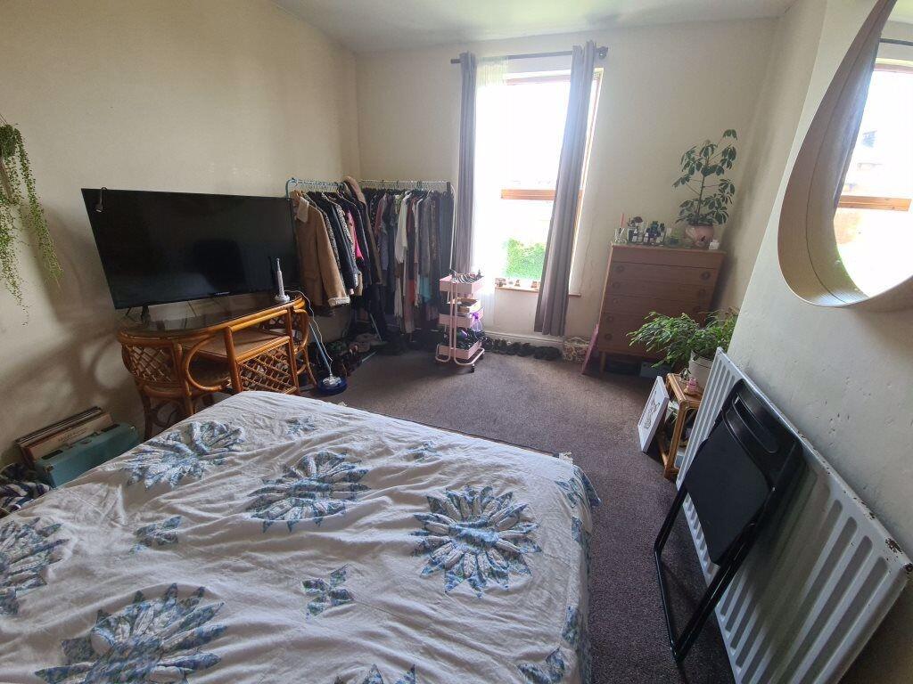 A cozy bedroom featuring a bed, a television, a...