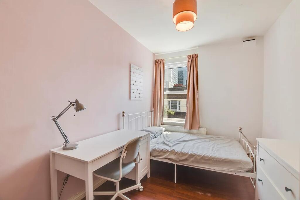 A bright and tidy single bedroom featuring a wh...