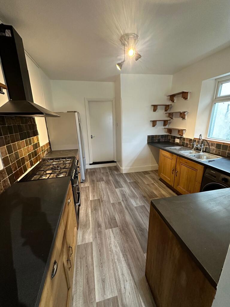A well-maintained galley kitchen featuring wood...